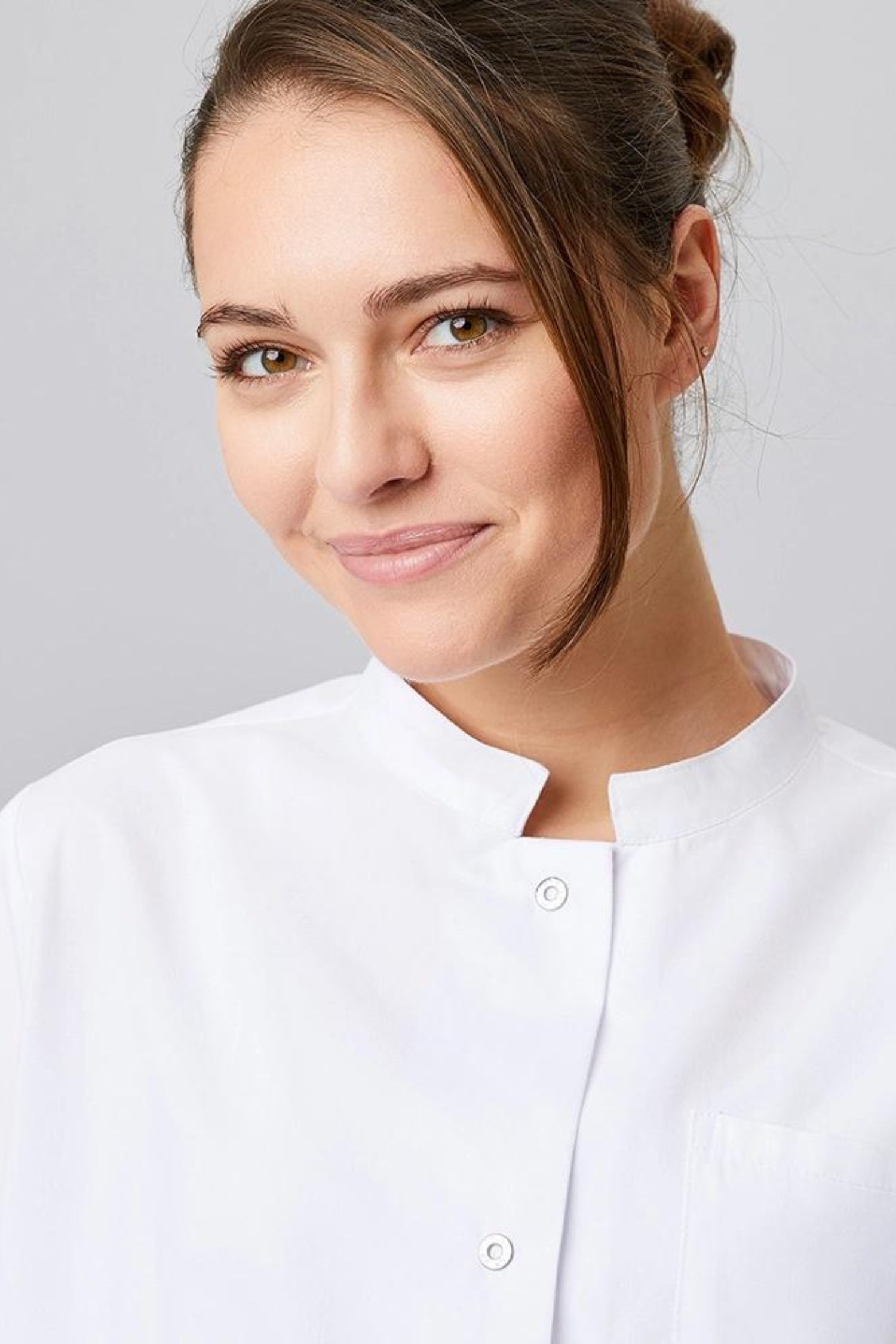 Femme souriante en blouse médicale blanche avec coupe confortable et calot médical