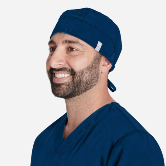 Homme souriant en calot chirurgien Grey’s et uniforme de médecine bleu