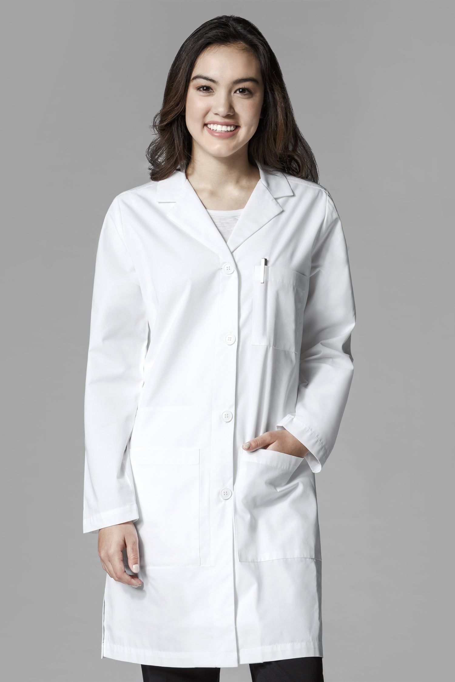 Blouse médicale femme blanche portée par une femme souriante avec des cheveux foncés