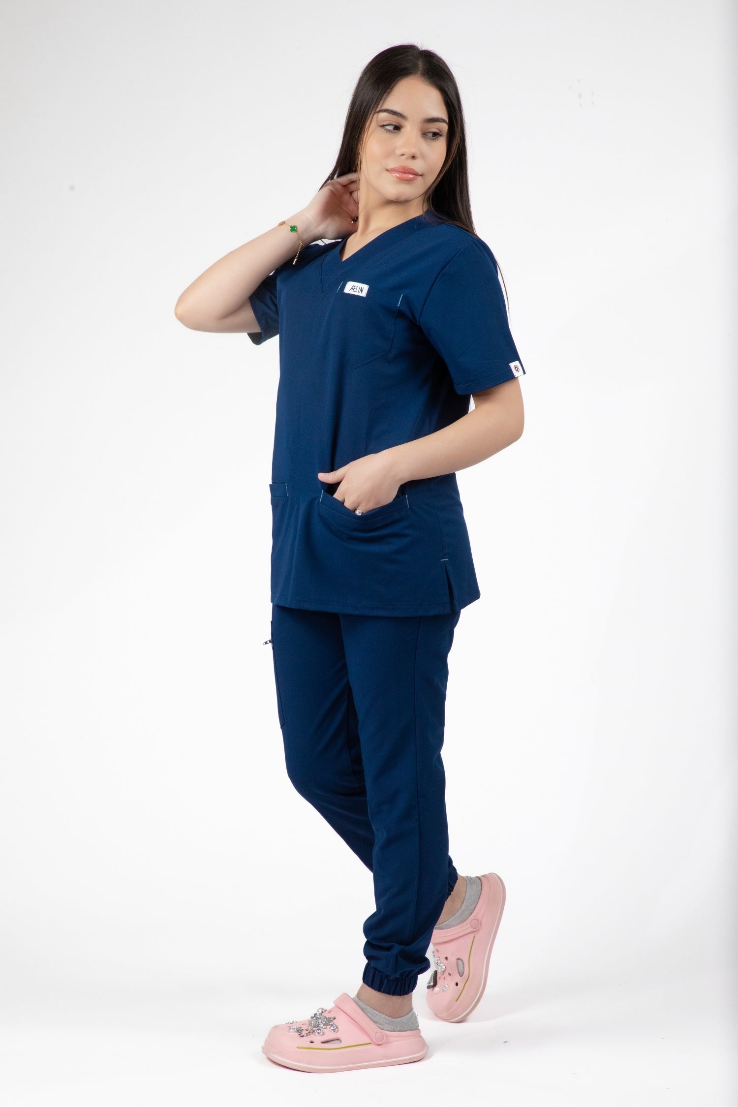 Une femme en uniforme médical bleu Slimfit NEW, comprenant une blouse et un pantalon