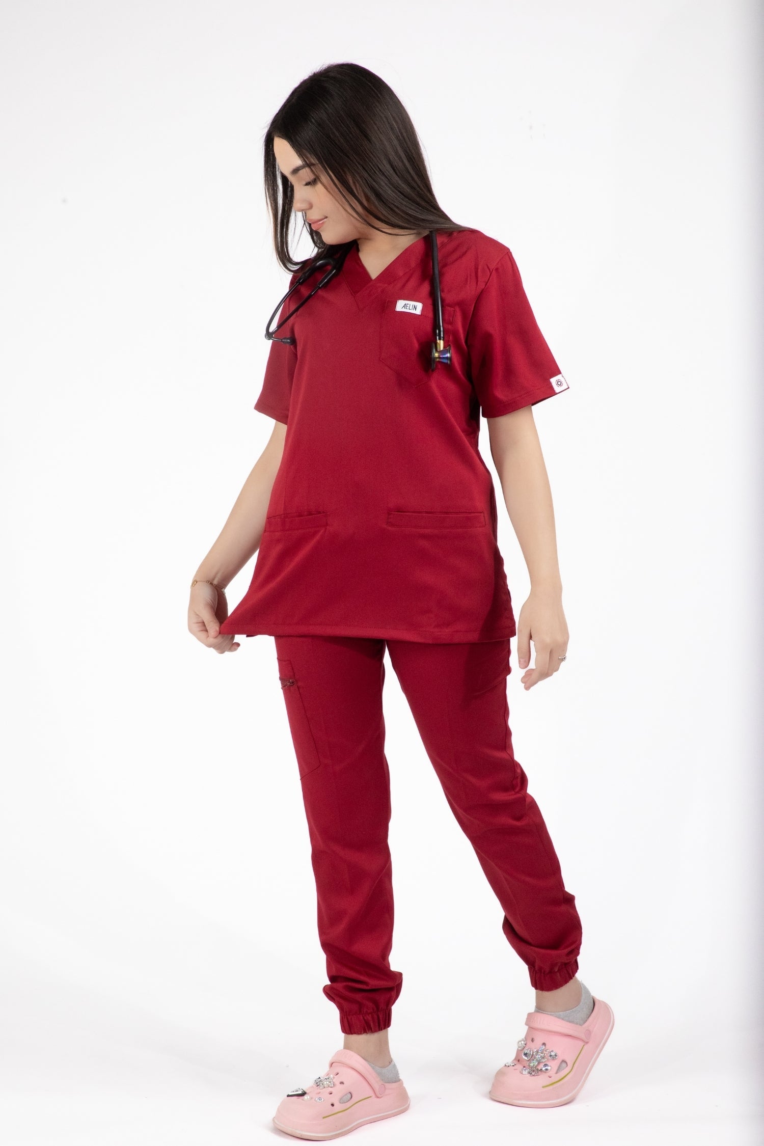 Jeune femme en uniforme médical rouge Slimfit NEW avec blouse et pantalon rouge Bordeaux